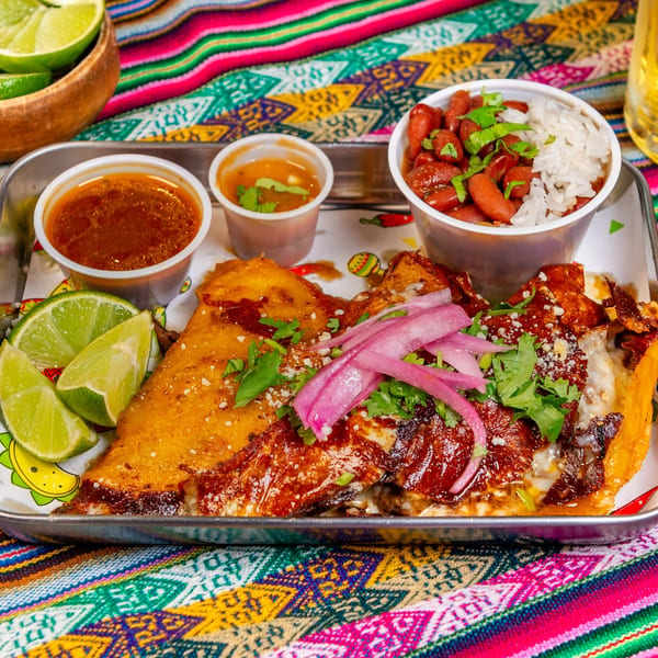 Cafe772 Cantina & Grill's Latin-American dish with a cheesy quesadilla, beans, rice, and lime wedges.
